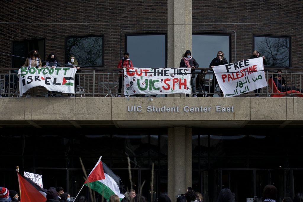 Students protesting at UIC holding a banner that reads "Cut the ties, UIC SPH"