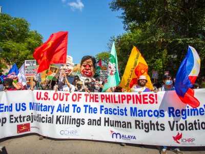 A protest banner at the March on the DNC reading "U.S. out of the Philippines! End US Military Aid To The Fascist Marcos Regime! Stop Extrajudicial Killings and Human Rights Violations!